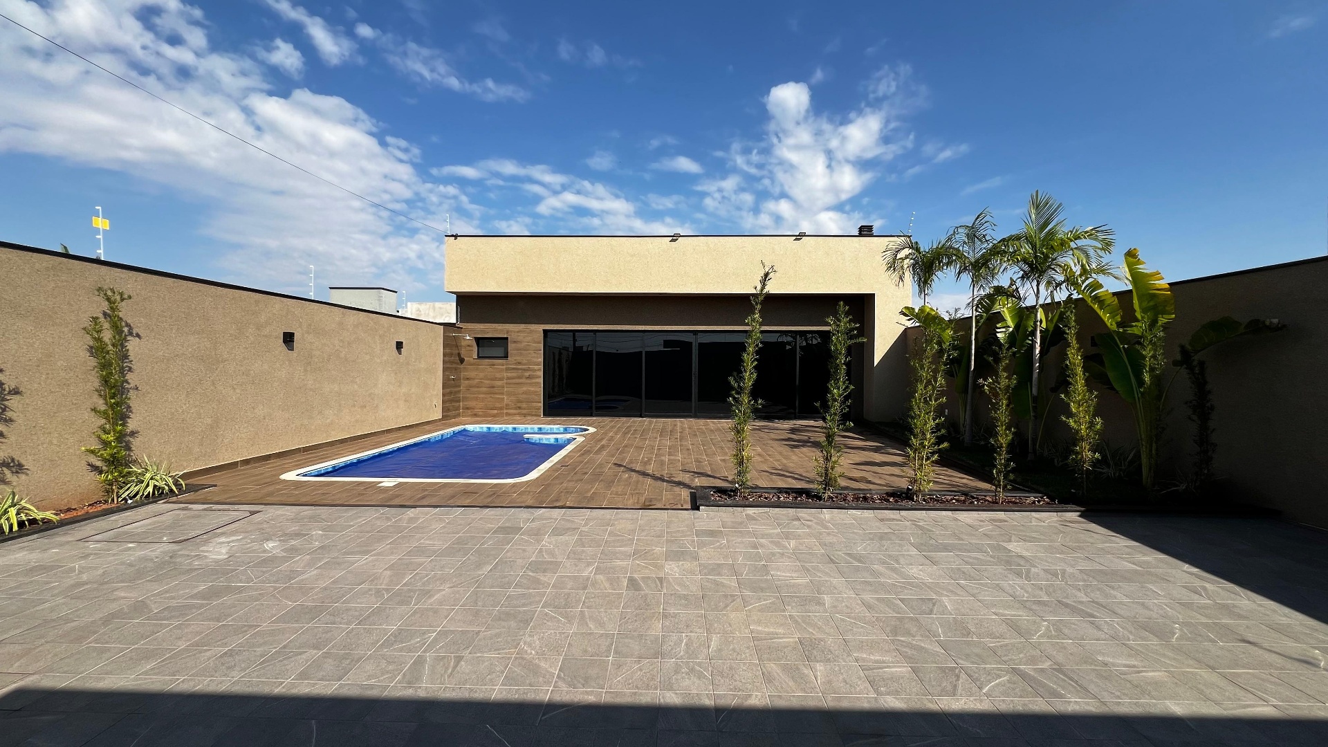 Área externa com piscina e deck amadeirado