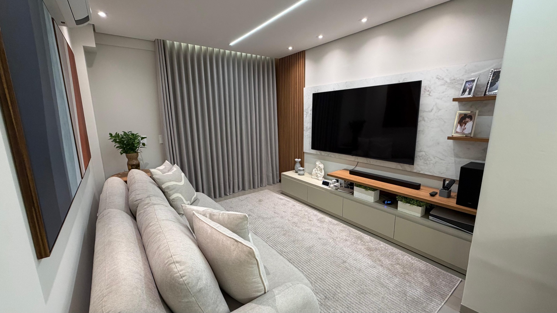 Sala de TV residencial com painel e marcenaria sob medida