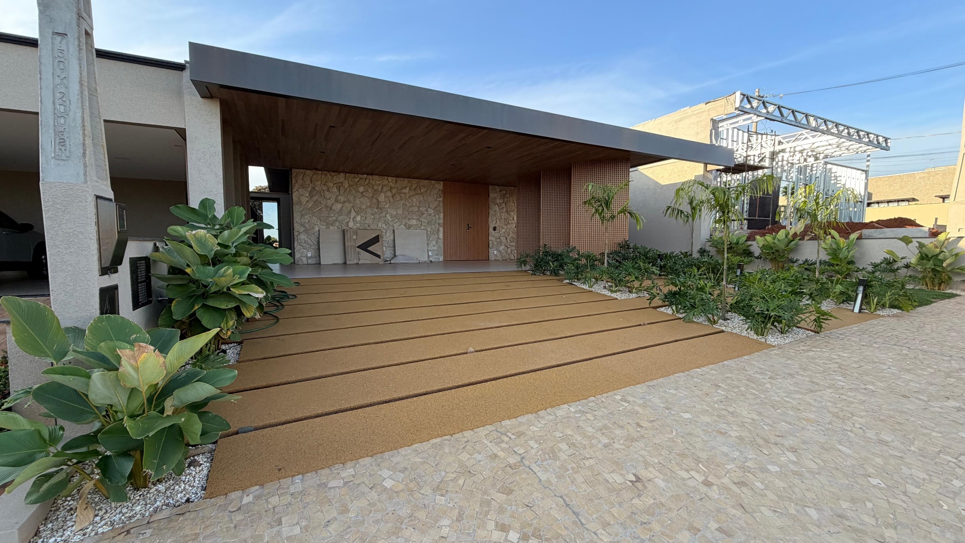 Fachada residencial com paisagismo e marcenaria
