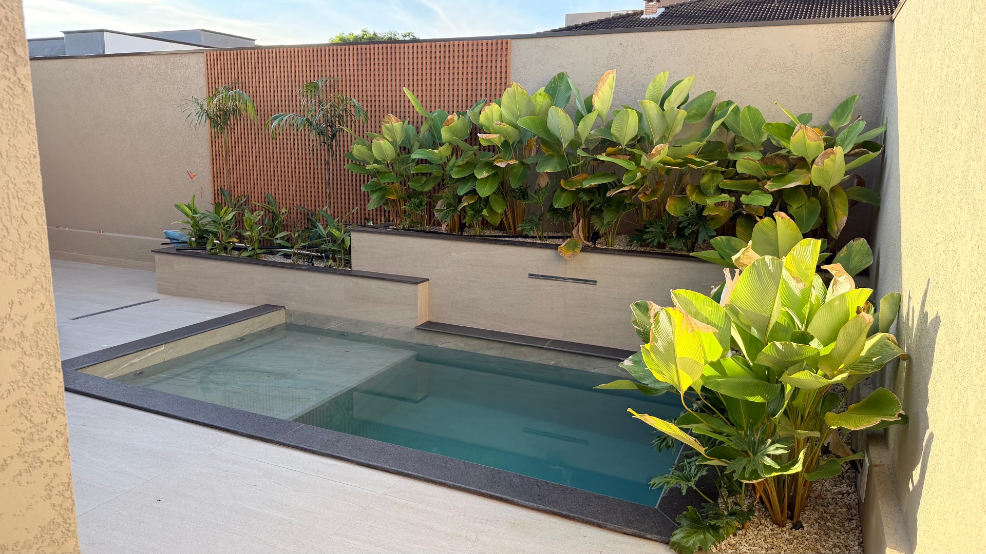 Piscina com jardim tropical em projeto residencial
