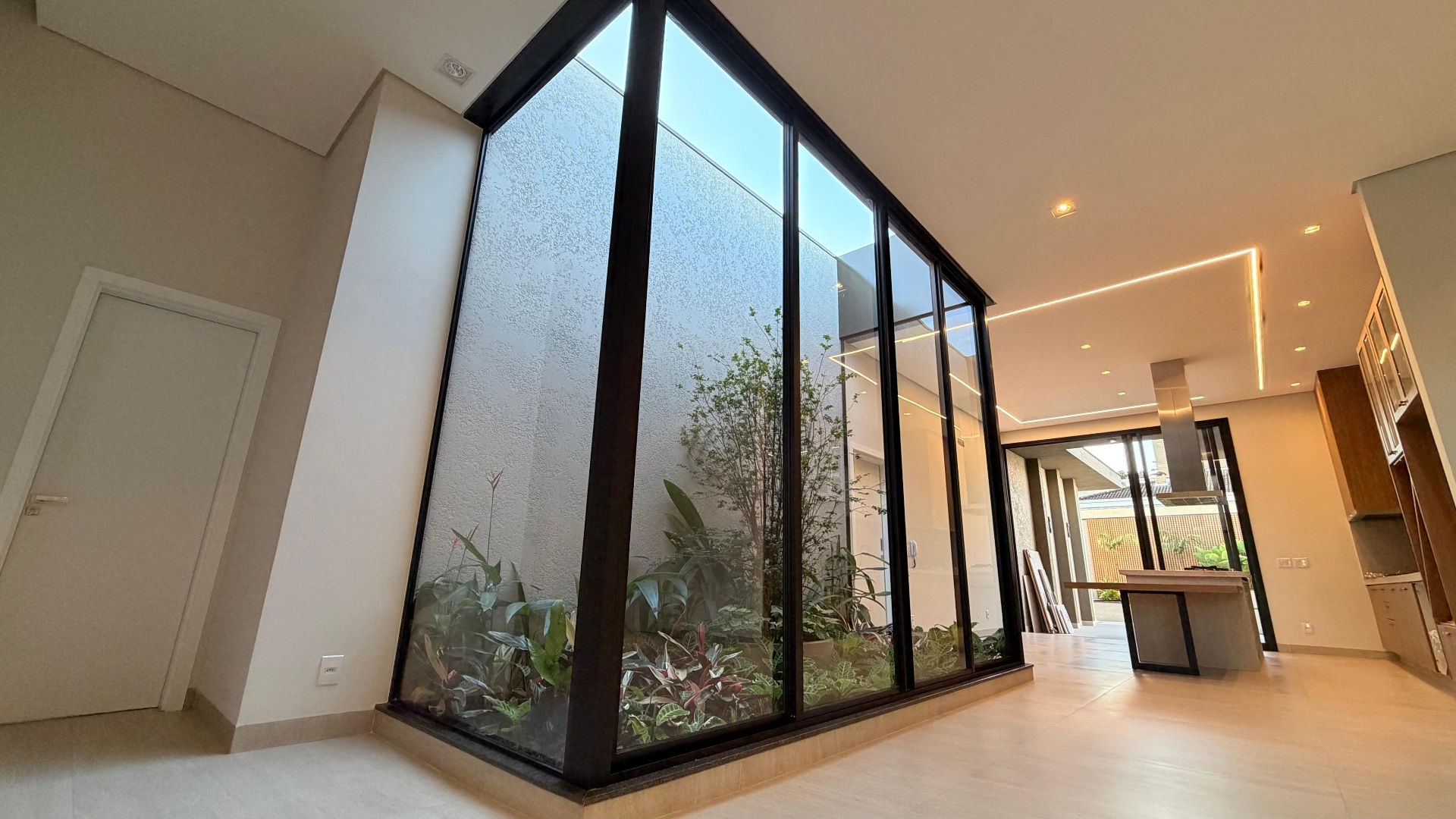 Ambiente interno com jardim central envidraçado